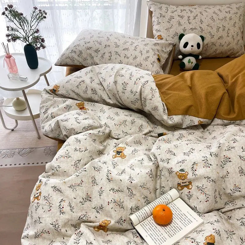 A bed covered in pink floral bedding set with a duvet cover and pillowcases, featuring small animal patterns.
