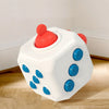 A white sensory ball toy with red and blue components resting on a wooden surface.