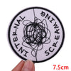 A round white patch with black embroidery spelling out INTERNATIONAL SCREAMING