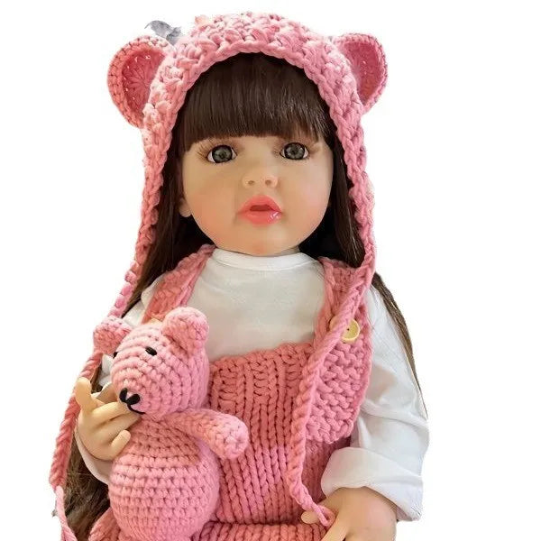 A lifelike silicone baby doll with pink ears and a matching knitted outfit.