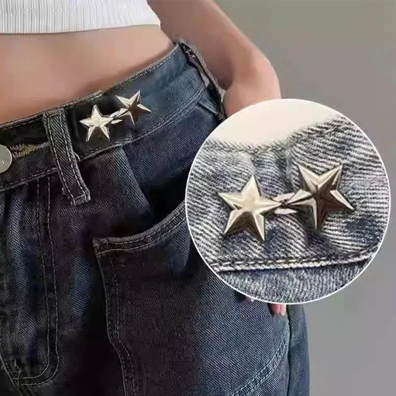 A close-up of dark denim jeans showing a metal star brooch belt buckle and waist pin clasp.