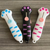 Three colorful retractable cat paw utility knives displayed on a gray wooden surface.