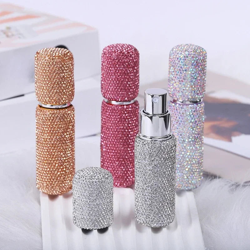 A collection of ten refillable glass perfume atomizers in various glitter colors including rose gold, pink, silver, and iride