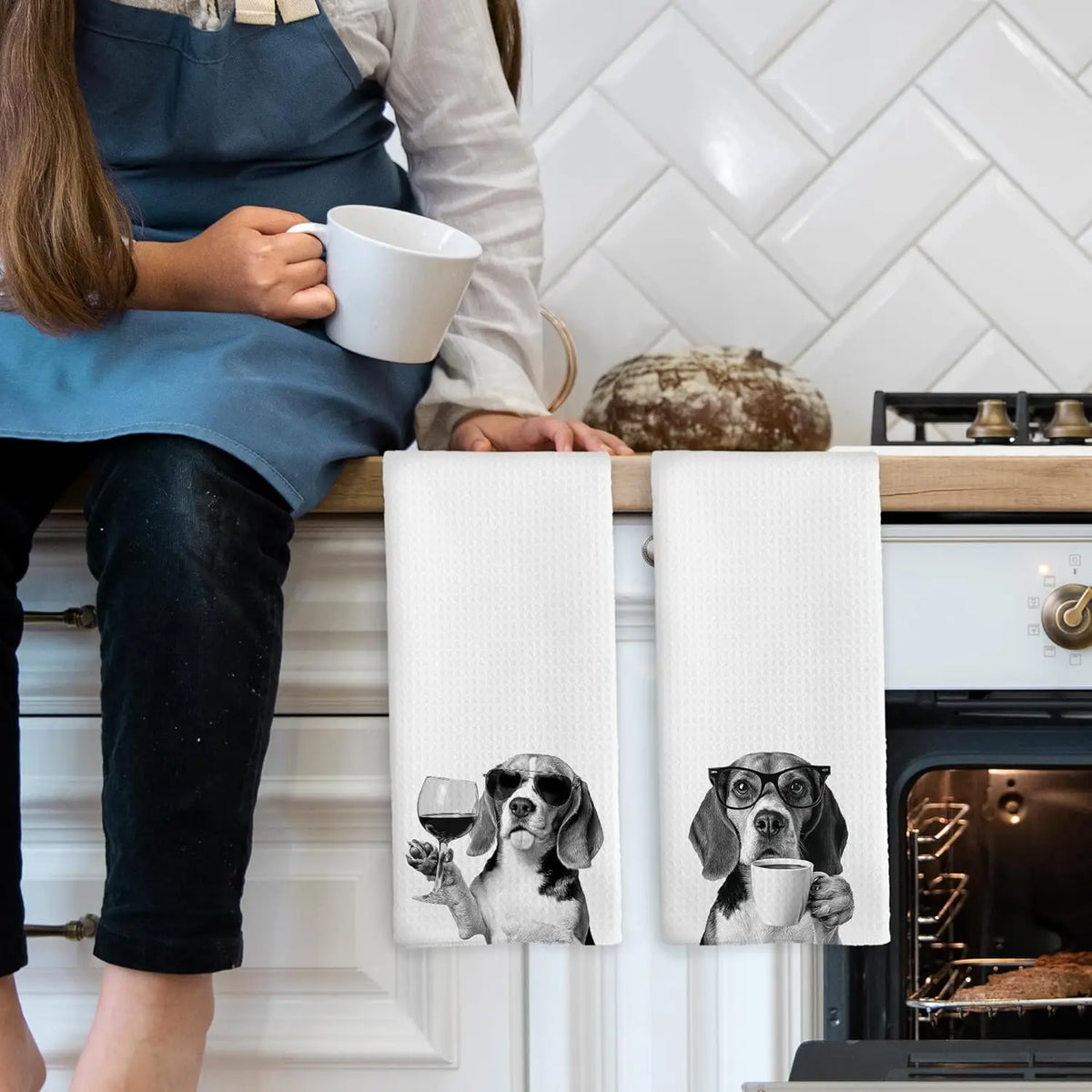 A set of two white kitchen towels featuring illustrations of dogs and glasses