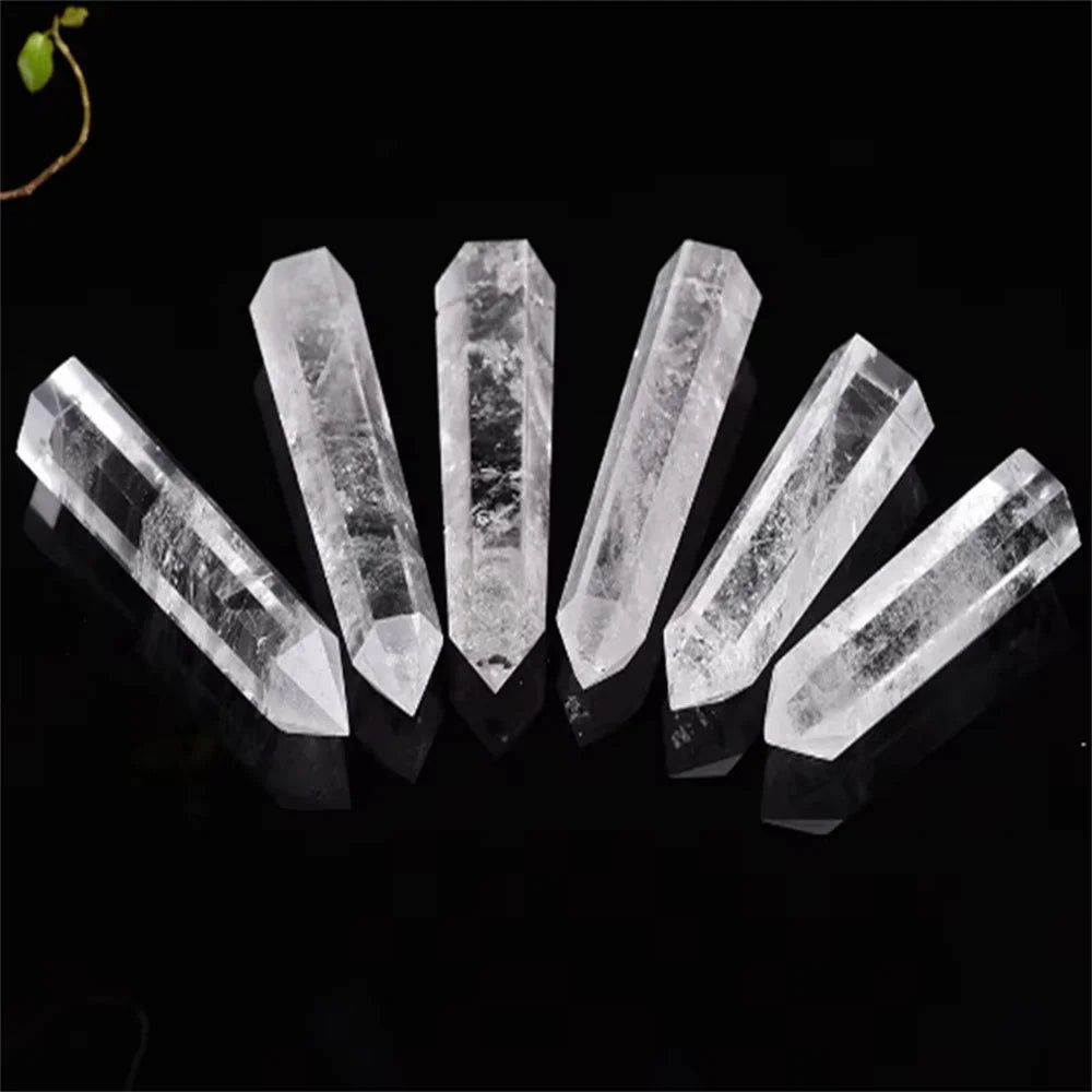 A row of natural clear quartz crystals cut into tower shapes displayed on a black background.