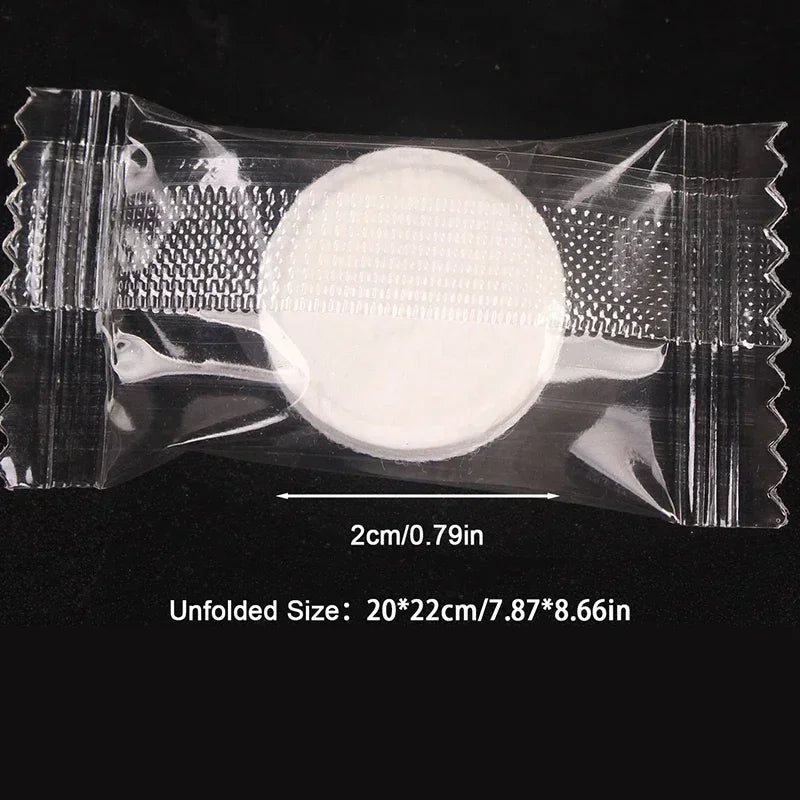 A clear plastic package containing a white, circular compressed cleansing towel.