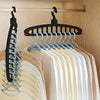 A display of multi-layer space-saving closet hangers in various shades of beige, white, and light blue.
