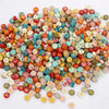 A pile of colorful acrylic alphabet letter beads in various shades and shapes for jewelry making