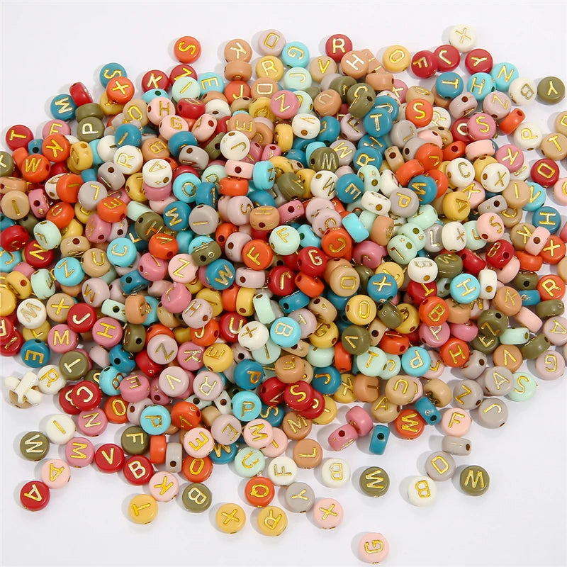 A pile of colorful acrylic alphabet letter beads in various shades and shapes for jewelry making