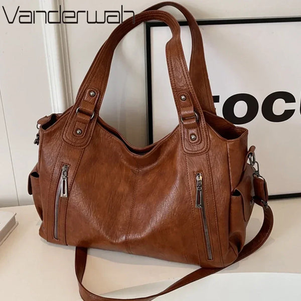 A brown vintage leather tote bag with multiple zippered pockets is displayed on a white surface.