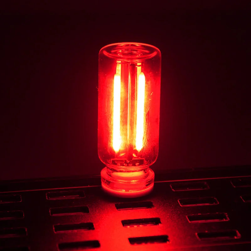 A glass accent LED night light glows bright orange-red on a dark surface.