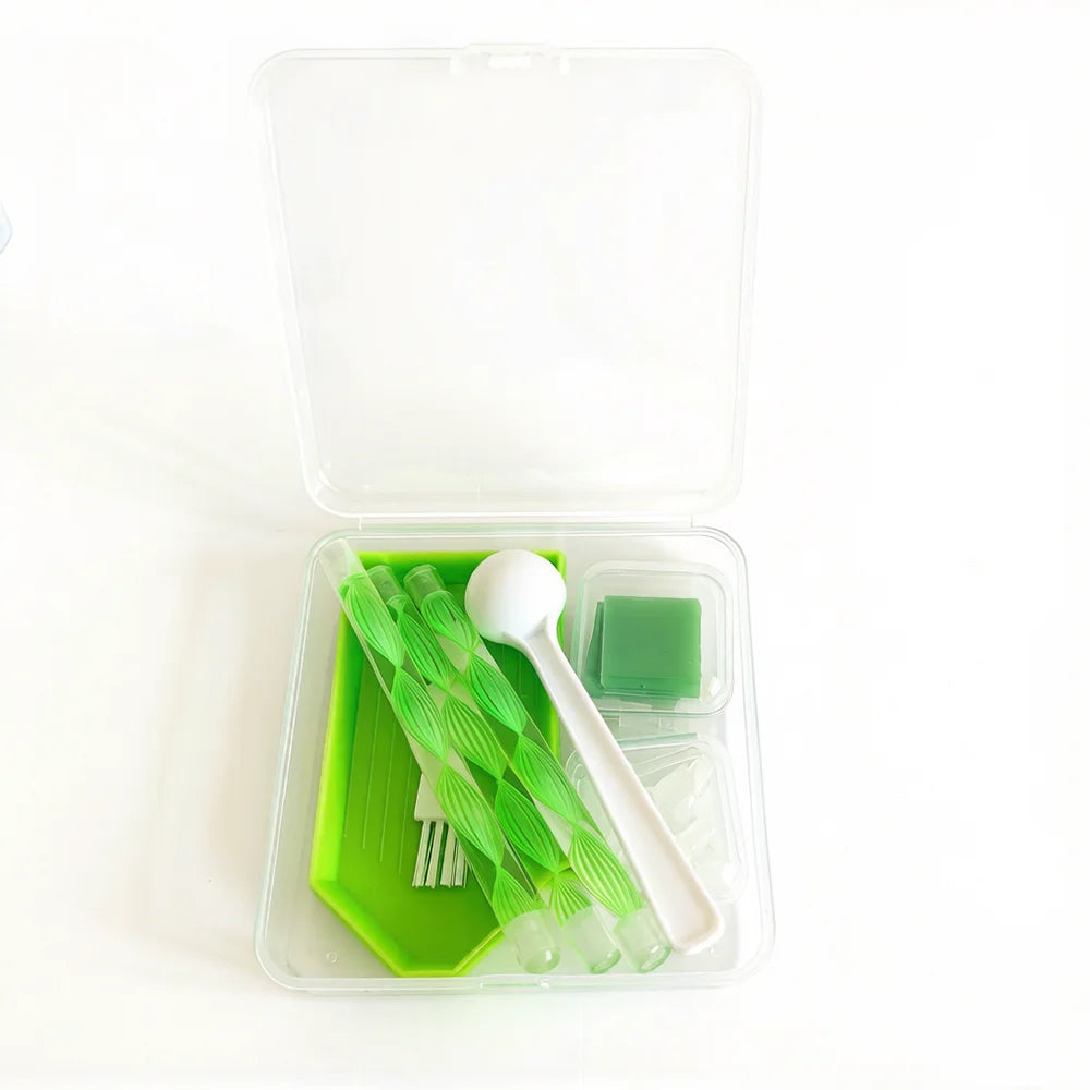 A clear storage box containing a complete diamond painting accessory kit with green tools and a green tray.