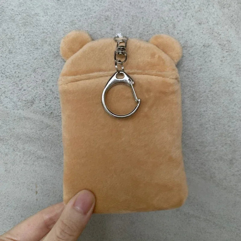 A tan Rilakkuma plush item used as an ID card holder and keychain.