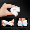 A hand holds a white melamine cleaning sponge, showing its flexible shape and texture.