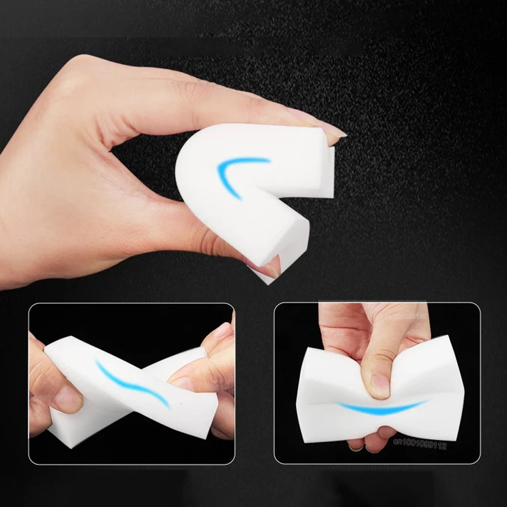 A hand holds a white melamine cleaning sponge, showing its flexible shape and texture.
