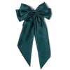 A dark teal silk bow used as a hair clip or ponytail holder.
