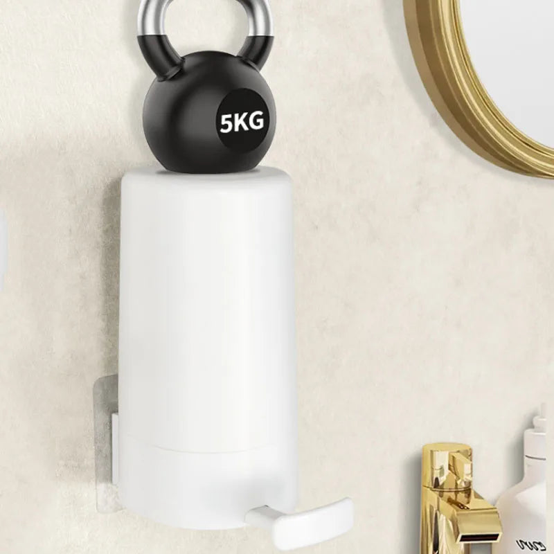 A white soap bar grinder and dispenser with a black top is mounted on a wall next to a gold-framed mirror.