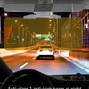 A car interior view showing an anti-glare visor extender with a night shield illuminating the road at night.