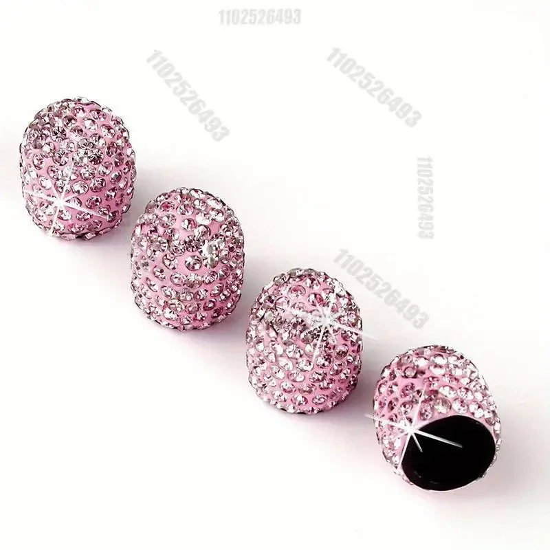 Several pink crystal-cut tire valve caps are displayed on a white background.