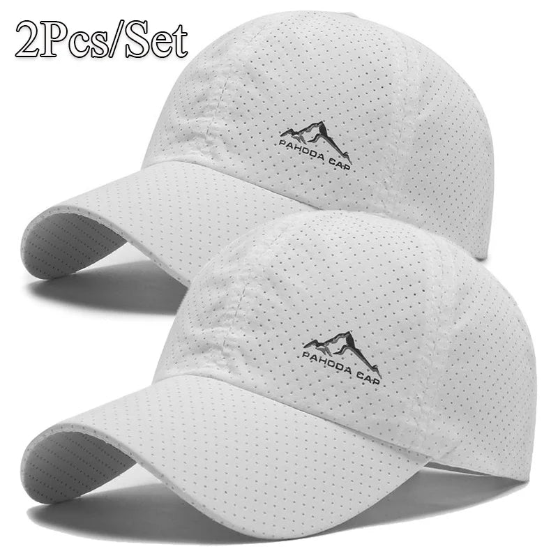 A set of two white quick dry baseball caps featuring a mountain logo embroidered on the front.