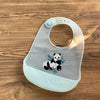 A light blue silicone baby bib featuring a cute black and white panda cartoon print.