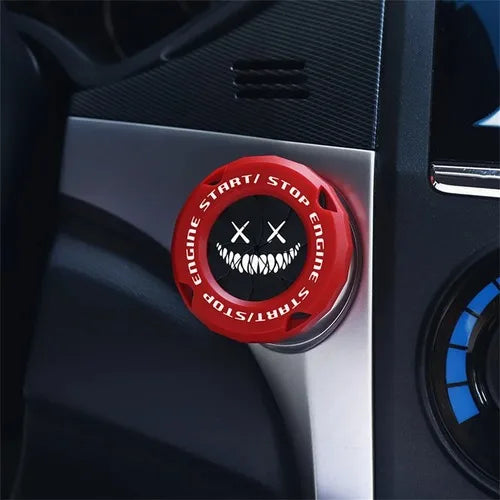 Close-up of a red and black rotating protective cover for a car ignition start button.