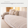 A beige textured anti-slip sofa cover with a herringbone pattern draped over a light-colored sofa.