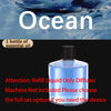 A clear bottle of essential oil with a black cap is shown against a blue ocean background.