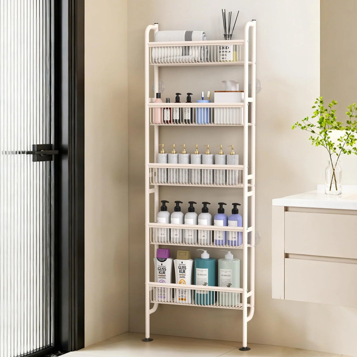A tall, white tiered storage rack with multiple shelves for bathroom or kitchen supplies is shown next to a glass door.