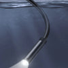 A close-up of a black inspection camera with a waterproof lens shining light underwater.