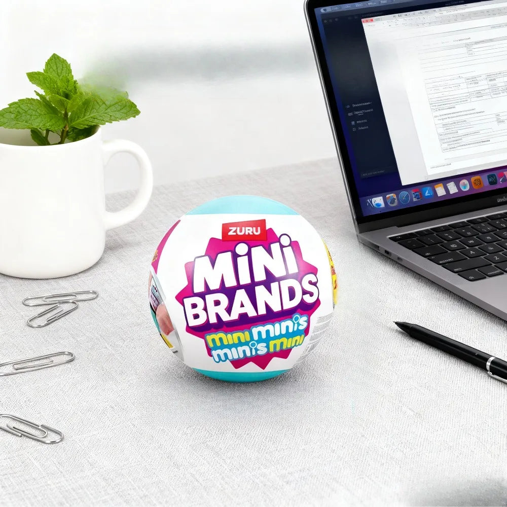 A small, round, light blue blind box featuring the Mini Brands logo and colorful packaging sits on a gray surface next to a l