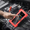 A hand points at a red intelligent car battery charger with an LCD display, positioned on a black vehicle surface.