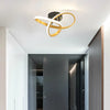 Modern clover-shaped LED ceiling light with a gold and white ring design mounted on a white ceiling.