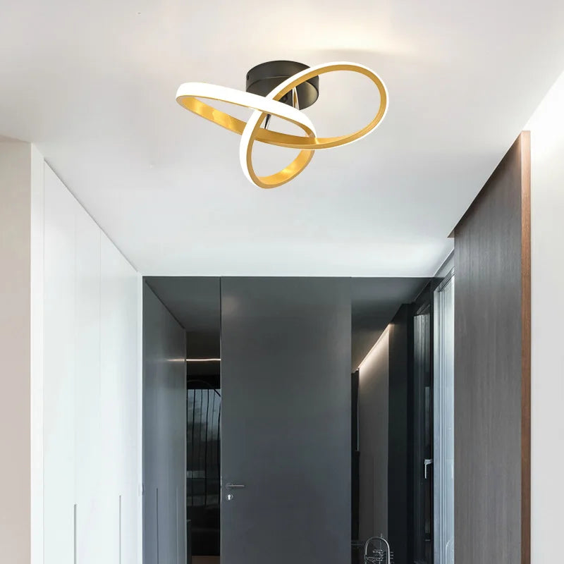 Modern clover-shaped LED ceiling light with a gold and white ring design mounted on a white ceiling.