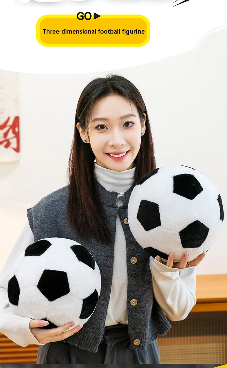 A woman holds a black and white football figurine against a gray cardigan.