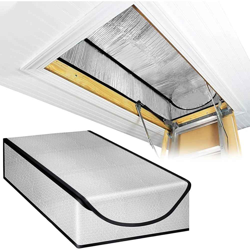 A silver attic stairway insulation cover with a sealed barrier shown installed under a white ceiling trim.