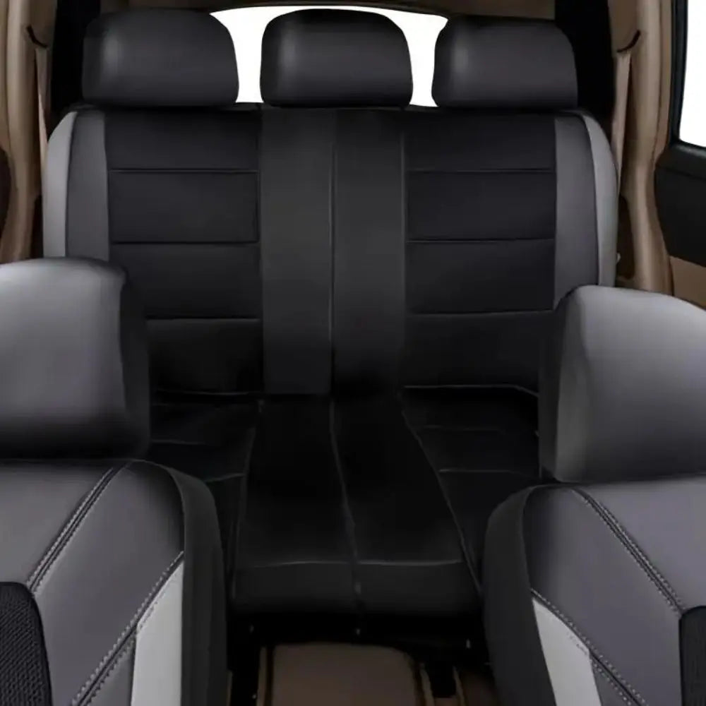 Interior view of a car with black leather seat covers and a front seat showing a gray and white accent.
