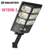A black motion-activated solar garden light with four LED floodlights mounted on a stand.