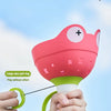 A hand is holding a pink flying saucer toy with a green pull ring, demonstrating its design.