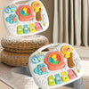 A white interactive baby learning table featuring animal sounds and piano keys, resting on a woven basket.