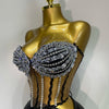 A gold mannequin displays a sparkly two-piece party outfit with a see-through top and black detailing.