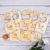 A set of wooden baby closet dividers used to organize clothing by size and age from newborn to 24 months.