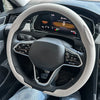 A close-up view of a steering wheel with a breathable leather cover installed in a car interior.