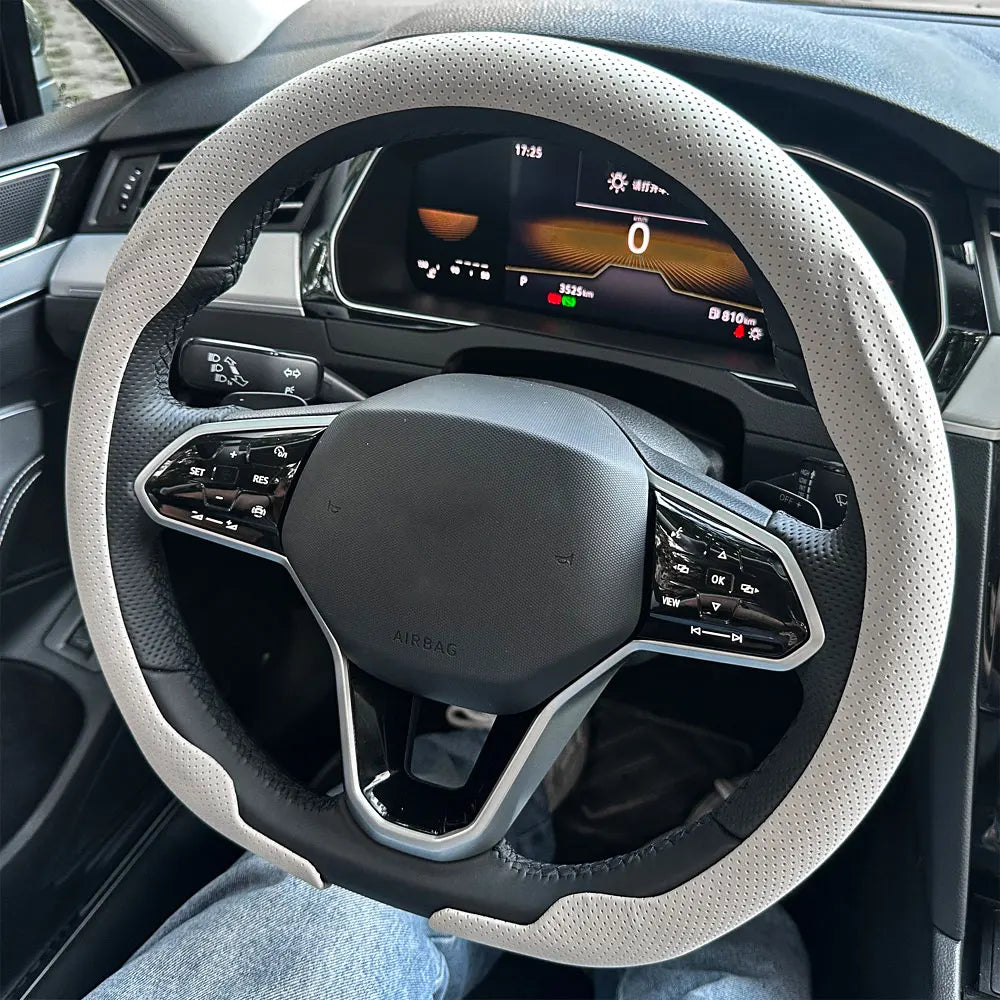 A close-up view of a steering wheel with a breathable leather cover installed in a car interior.