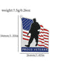 Silver enamel pin featuring a silhouette of a soldier against an American flag background with the text PROUD VETERAN