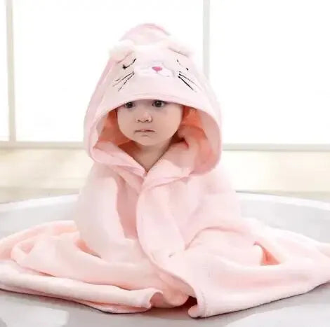 A baby wearing a pink hooded bathrobe towel with a cartoon cat design.