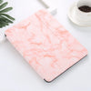 A pink marble patterned case for an iPad Pro with a built-in pencil holder resting on a white surface.
