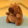A brown plush toy resembling a capybara is sitting on a light blue surface.