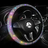 A black steering wheel covered in sparkling crystal rhinestones, featuring a Mercedes logo.