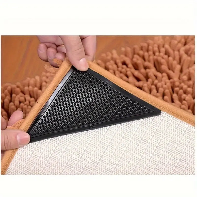 A black non-slip rug pad gripper is shown being placed onto a light-colored rug or floor surface.